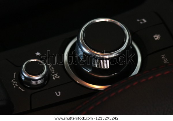 New modern car\
interior details. Volume and channel media control stick buttons\
that decorating with silver chromium near the black leather driver\
seat side in modern car\
interior.