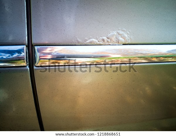 New modern car with Rust\
and Corrosion and paint bitumen. rust car door damage, corrosive\
defect of iron
