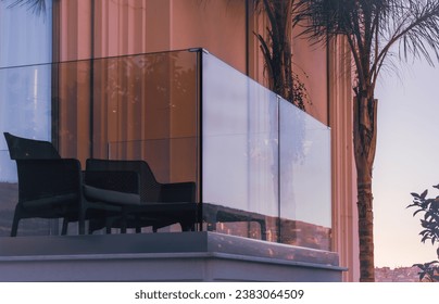 New modern glass balcony railing. Balcony railings made of glass and stainless steel. Apartment with glass balcony terrace of modern architecture house by the sea