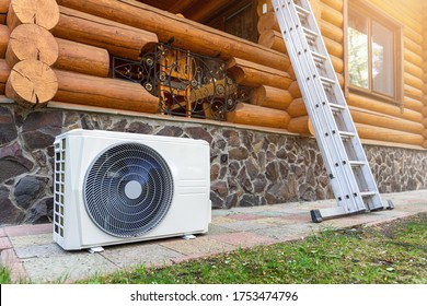 New Modern HVAC Air Conditioning External Compressor Unit Preapred For Installation Or Replacement Near Wall Of Wooden Log Residential Country Cottage. Ladder And Equipment For Service And Maintenance