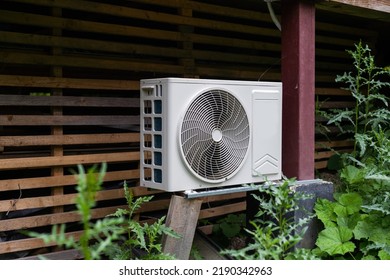 New Modern HVAC Air Conditioning External Compressor Unit Preapred For Installation Or Replacement Near Wall Of Wooden Log Residential Country Cottage. Ladder And Equipment For Service And