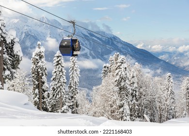 New modern spacious big cabin ski lift gondola against snowcapped forest tree and mountain peaks covered in snow landscape in luxury winter alpine resort. Winter leisure sports, recreation and travel