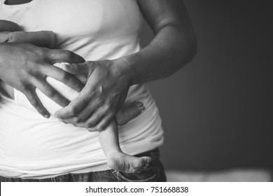 New Mom Holding Newborn Baby In Her Arms In Hospital Room. Film Grain Look