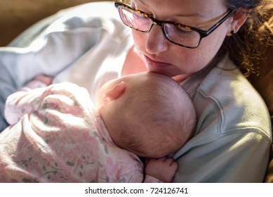 New Mom Napping With Baby In Her Arms