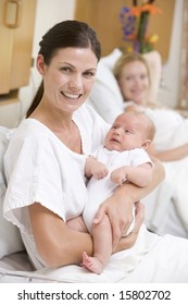 New Mother With Baby In Hospital Smiling