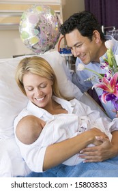 New Mother With Baby And Husband In Hospital Smiling