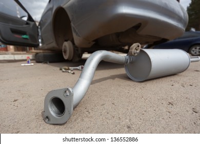 The New Muffler Against The Dirty Car Without Wheels