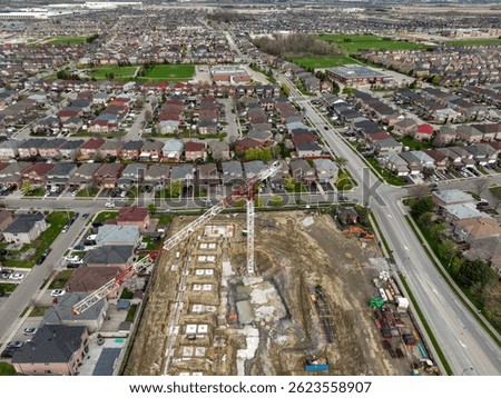 A new multi storey building rises in a suburban neighbourhood, highlighting the potential tension between community growth and local resistance to development.