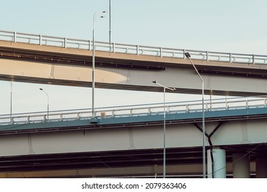 New multilevel road junction, bottom view. Overpasses one above the other. Road fence and road lighting poles