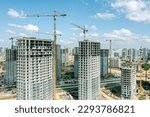 new multistory apartment buildings under construction with cranes on construction site. aerial drone photo.