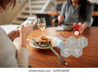 New Nordic Cuisine, Technology And People Concept - Woman With Food On Smartphone Screen And Nutritional Value Chart R At Restaurant