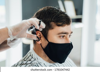 New Normal Adapting To Normal Life After Pandemic Lockdown. Man Getting Haircut Wearing Mask.