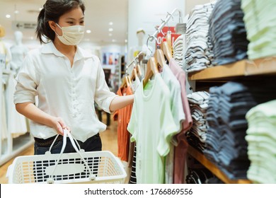 New Normal After Covid Epidemic Yound Asian Female Wear Face Mask Protection Shopping Dress Or Cloth In Boutique Shop New Lifestyle In Department Store Mall Background