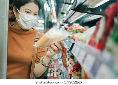 new normal after covid epidemic young smart asian female shopping new lifestyle in supermarket with face shild or mask protection hand choose fresh vegetable of fruit new normal lifestyle