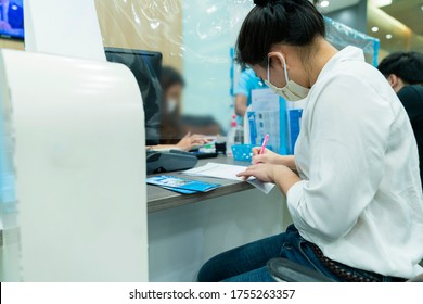 New Normal Asian Female Sit And Write Paper Work At Commercial Bank With Face Mask And Social Distancing New Lifestyle After Covid 19 Spread Epidemic