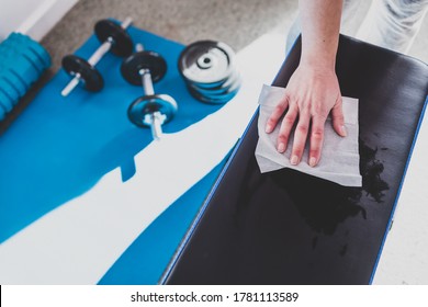 the new normal for businesses after covid-19, hand cleaning gym equipment with disinfectant wipe against virus and bacteria - Shutterstock ID 1781113589