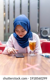 New Normal Concept, Cute Malay Girl At The Coffee Shop Using Smart Phone