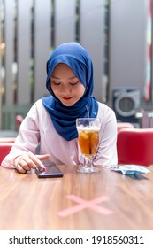 New Normal Concept, Cute Malay Girl At The Coffee Shop Using Smart Phone