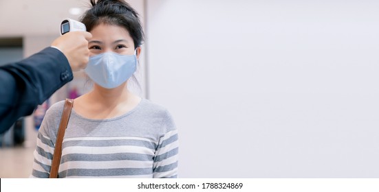 New Normal Guard Using Digital Medical Electronic Thermometer Measures Temperature Screening Asian Female Customer Protective Preventing Spread Diseases  Of Coronavirus In Department Store