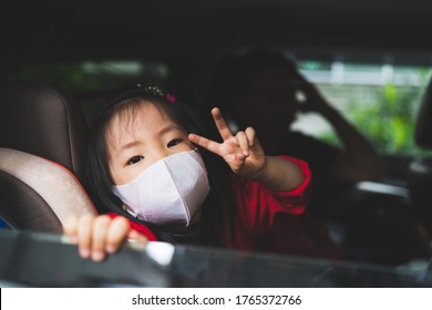 New Normal Kid Toddler Wearing Face Shild Or Face Mask When Come Out Side From Home To Prevent Coronavirus Or Germ From The Dirty Air In Public Area. Asian Kid Wearing Surgical Mask In The Car.