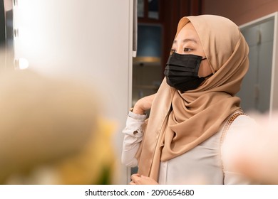 New normal retail shopping: Cute Malay girl wearing headscarf and mask at the store