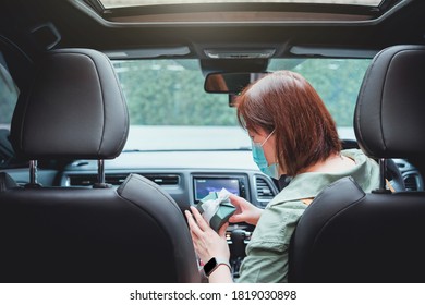 New Normal And Social Distancing Concept With Asian Woman Wear Protective Mask And See Gift Box In Her Car