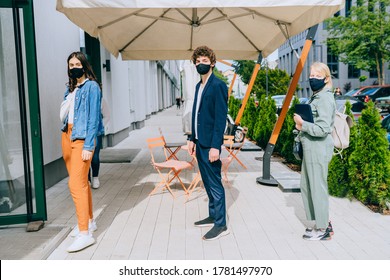 New Normal And Social Distancing When Go Back To Work After Coronavirus Covid 19 Spread Concept. People Wearing Mask Keep Distance When Waiting Near Local Shop Or Cafe.