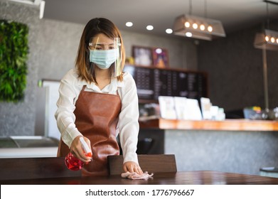 New Normal Startup Small Business Portrait Of Asian Woman Barista Wearing Protection Mask And Face Shield Cleaning Table In Coffee Shop While Social Distancing