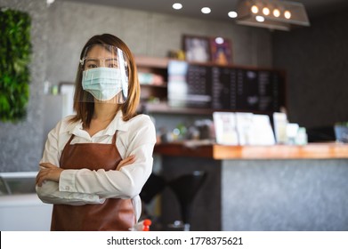New normal startup small business Portrait of Asian woman barista wearing protection mask stand in her coffee shop while social distancing