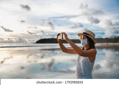 New Normal Travel Concept, Happy Traveler Asian Woman With Mask And Mobile Phone Sightseeing In Kata Beach, Phuket, Thailand