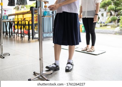 New Normal,Asian Student Is Using Their Foot To Press The Alcohol Antiseptic Gel,foot Pedal On Alcohol Gel Equipment,reduce Touch,child Girl With Hand Sanitizer,new Normal Life And Social Distancing