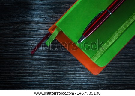 New office pocketbooks pen on wooden board.