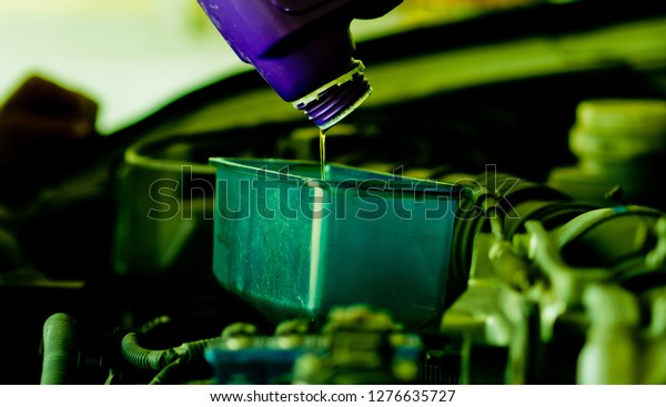 new oil into car, pouring fresh oil, service\
car station\
