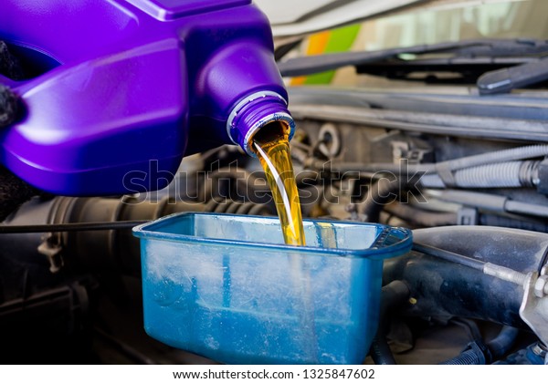 new oil into car, pouring fresh oil, service\
car station\
