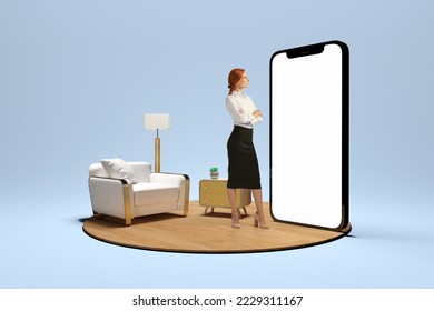 New opportunities, modern lifestyle. Young girl standing in front of huge 3d model of cellphone with blank white screen and thinking isolated on blue background. Online working, payment, new app