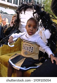 New Orleans - February 20, 2010: 
Selective focus on little girl in New Orleans Saints cheerleader dress with parasol day exterior             