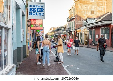 New Orleans, LA - October 25, 2021: People Speak With A Street Performer On Bourbon Street In The French Quarter.