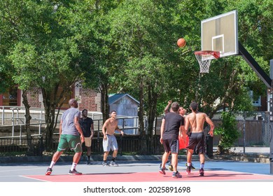 NEW ORLEANS, LA, USA - AUGUST 14, 2021: Young Men Playing Pickup Basketball Outdoors