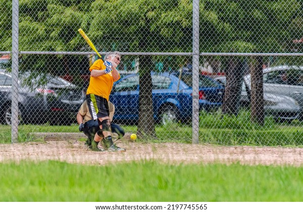 NEW ORLEANS, LA, USA - AUGUST\
11, 2019: Softball batter swings and misses at pitched\
softball
