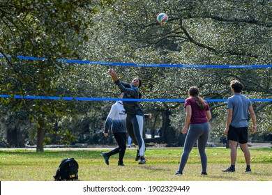 NEW ORLEANS, LA, USA - JANUARY 2, 2021: Pickup volleyball game featuring female setter and ball in motion, in Audubon Park