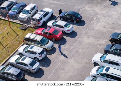 NEW ORLEANS, LA, USA - JANUARY 28, 2021: Aerial View Of Parking Lot Full Of Cars And Hospital Worker Walking To Work