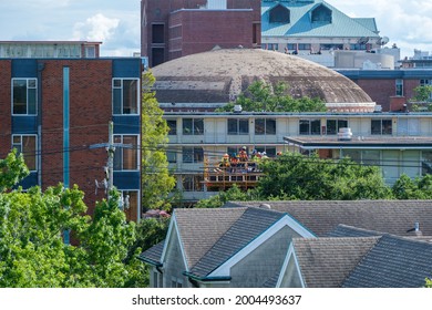 NEW ORLEANS, LA, USA - JULY 1, 2021: Crew Of Construction Workers Amidst A Diversity Of Rooftops At Tulane University 