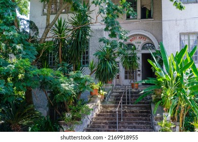 NEW ORLEANS, LA, USA - JUNE 20, 2022: Grand Entrance To Rose Apartment Building With Front Steps And Lush Garden In The Lower Garden District