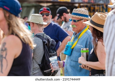 NEW ORLEANS, LA, USA - MARCH 30, 2019: Baby Boomer With Green Mustache Selectively Focused Among The Crowd At An Outdoor Festival