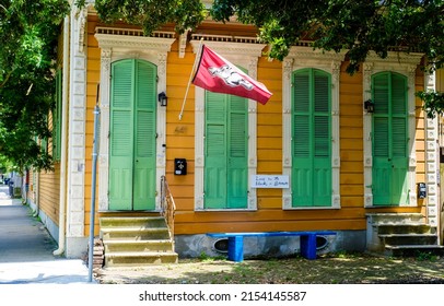 NEW ORLEANS, LA, USA - MAY 7, 2022: Tricolored Historic Shotgun House With An Arkansas Razorback Flag In The Bywater Neighborhood