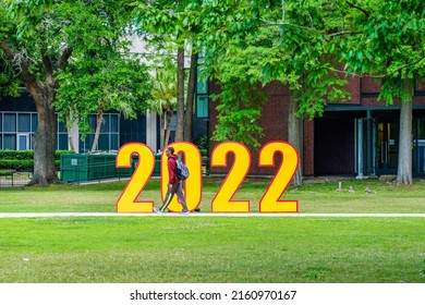 NEW ORLEANS, LA, USA - MAY 12, 2022: Black College Student Passing In Front Of The Numerals For The Year 2022 At Loyola University Campus During Graduation Week