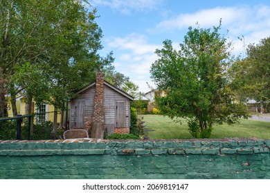 New Orleans, LA, USA - OCTOBER 30, 2021: Wooden Cabin In Backyard Of Home With Old Brick Wall In Foreground Near Bayou St. John