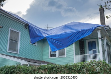 NEW ORLEANS, LA, USA - SEPTEMBER 7, 2021: Blue Tarp on Roof of Damaged Home From Hurricane Ida
