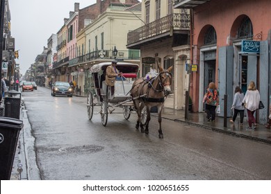 New Orleans, LA/USA - Jan. 28, 2018: Wide angle view of a horse drawn carriage rolling along Bourbon Street. Horses are commonly seen in the French Quarter, a historically interesting district.