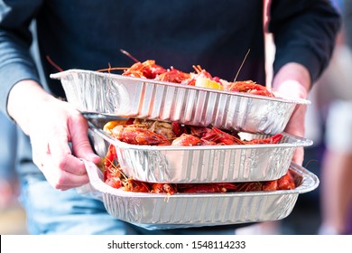 New Orleans, Louisiana City With People By Restaurant Carrying Seafood Lobsters Crawfish Holding Stack Of Many Trays